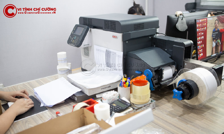 Nhân viên vận hành máy in nhãn OKI Pro1040 tại xưởng in tem hộp giày